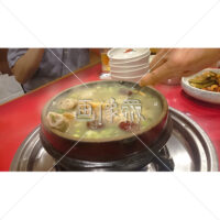 参鶏湯(サムゲタン)・韓国料理・トゥッペギを混ぜている写真素材