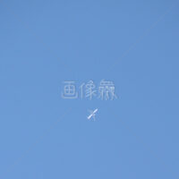 晴天の中飛ぶ飛行機の写真素材