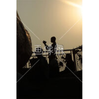 逆光で祈りを捧げる人の写真