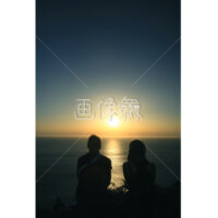 ヨーロッパの夕日を見る恋人の写真