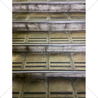 雨の日の駅のホームへ上がる古いコンクリート階段の写真素材