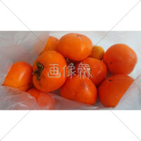 袋に入ったたくさんの柿の写真素材